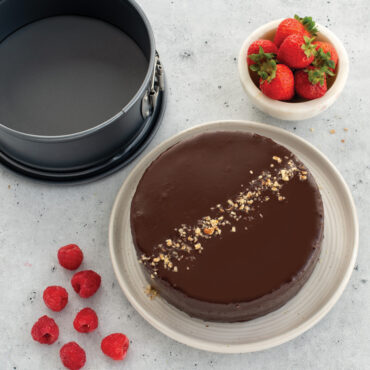 chocolate cake with nuts plated next to 7in springform pan