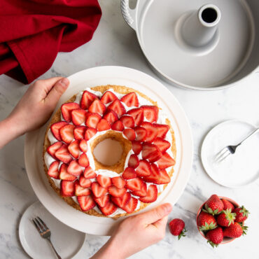 frosted pound cake topped with strawberries made with Nordic Ware aluminum pound cake pan with center tube