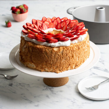 frosted pound cake topped with strawberries made with Nordic Ware aluminum pound cake pan with center tube