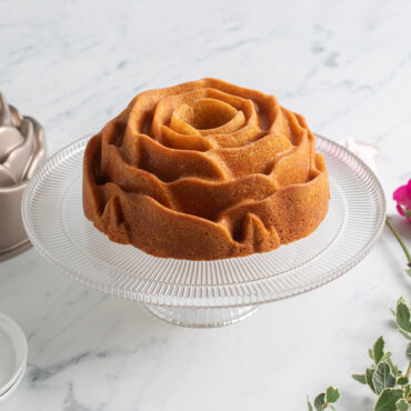 Plain Rose Bundt cake on clear cake stand