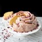 baked vanilla rose Bundt with white glaze on cake stand, slice cut from cake on plate