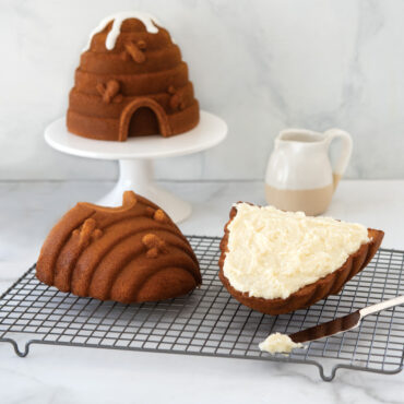 Assembled beehive-shaped aluminum cake pan on wire cooling rack, showing dome top and textured base pieces
