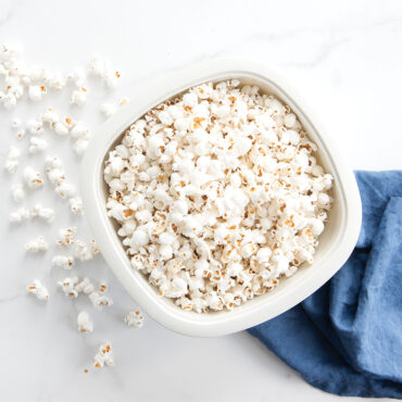 Nordic Ware white microwave popcorn popper filled with fluffy popped kernels