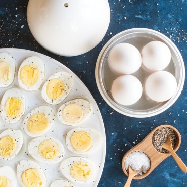 Microwaved eggs in open boiler, sliced hard-boiled eggs on platter, salt and pepper server