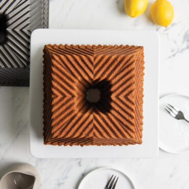 Plain Bundt Squared cake on white cake stand, overhead