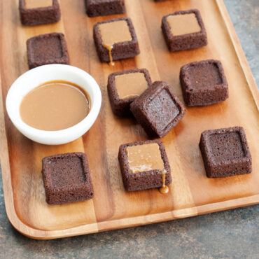 brown brownie bites baked in Nordic Ware pan, some topped with caramel drizzle, others plain