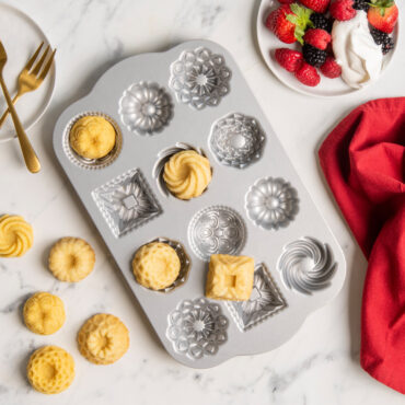 Nordic Ware Bundt Charms aluminum baking pan with 12 mini cavities in assorted fluted designs, silver nonstick