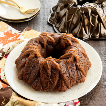 Baked pumpkin cake in Harvest Leaves Bundt Pan, angled with pan in background