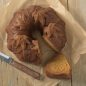 Top view baked spice Harvest Leave Bundt cake on parchment paper, slice cut from cake