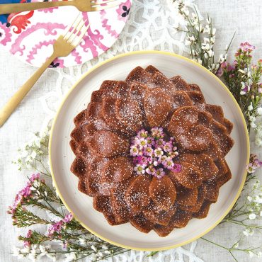Baked Blossom Bundt on platter with flowers, plates on side