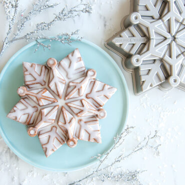 Glazed Snowflake cake on platter with pan on surface