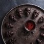 Dark chocolate skull cakelets on large circular platter, chocolate and red swirled glaze in the middle