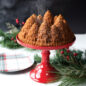 Baked pine forest cake on a red cake stand, holiday greenery in background