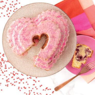 Baked vanilla Tiered Heart Bundt cake with light pink glaze