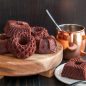 Chocolate Geo Bundt cakes on wood tray, mug with glaze in background
