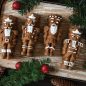 Baked spice Nutcracker cakelets with white piped frosting details, pine decorations