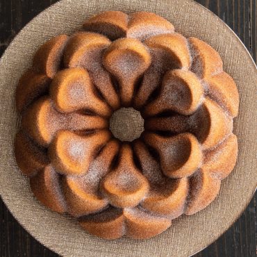 Baked Magnolia cake on plate, dusted with sugar