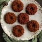 Six baked Wreathlette cakes on a plate in holiday scene