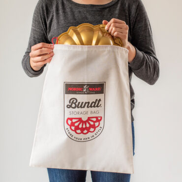 Bundt Storage Bag with logo on front and drawstring with person putting bundt in bag