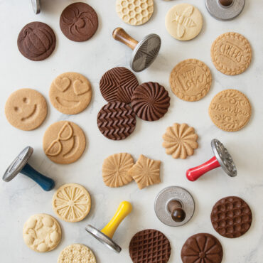Baked stamped cookies on surface showcasing entire cookie stamp collection