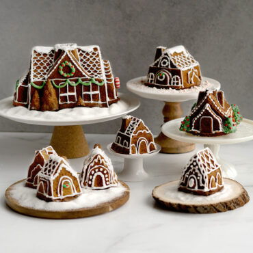 Baked gingerbread house cakes, decorated on platters