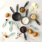 Overhead group image of measuring spoons and cups, some filled with ingredients