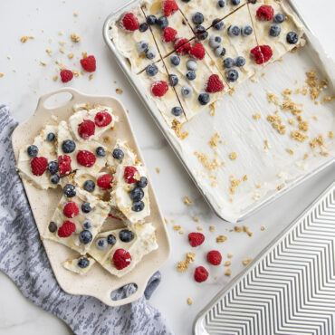 Yogurt Bark in a sheet pan with a tray of yogurt bark pieces next to it