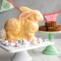 Baked bunny cake standing on cake stand, glazed, Easter scene