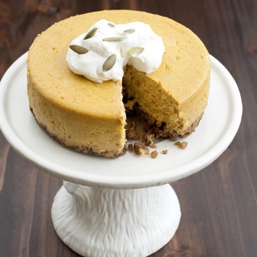 Baked pumpkin cheesecake, whipping cream garnish on cake stand