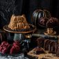 Halloween baking display, Haunted Manor Bundt cake, skull cakelets, and tombstone cakelets with decorations