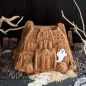 Moving GIF, candy ghosts appearing and disappearing on baked Haunted Manor Bundt Cake in Halloween display