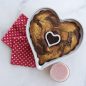 Baked marble cake in heart pan, bowl of berry glaze