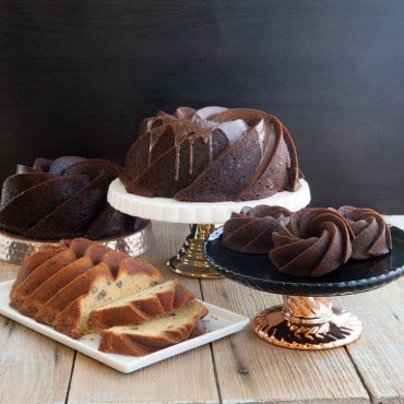 Four different version of Heritage cakes - baked chocolate cakes 10 cup, 6 cup, bundtlettes, vanilla loaf with nuts, all on serving plates