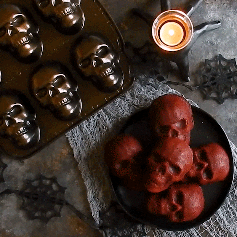 Moving GIF, disappearing skull cakes on plate with pan and candle