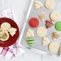 Baked cookie cut outs and holiday stamped cookies on ornament embossed baking sheet