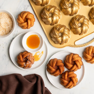 mini bundts on white serving plates with caramel drizzle and coconut flakes made with Nordic Ware aluminum braided mini bundt pan