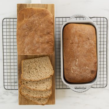 ProCast Classic Loaf Pan with baked bread baked in pan and one on a cooling rack.