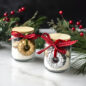 Two jars of ingredients with gold and silver ornament wrapped around jar, holiday background.