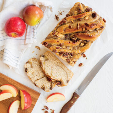 Braided apple babka loaf in Nordic Ware aluminum loaf pan, sliced to show swirled filling