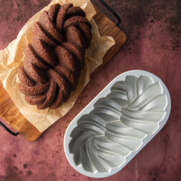Golden braided loaf cake baked in Nordic Ware aluminum braided loaf pan, showing detailed rope pattern