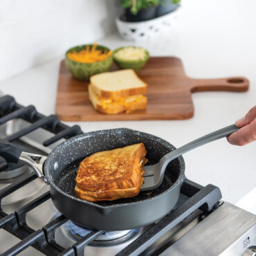 A side angle of the 8" ceramic coated skillet on the stovetop cooking grilled cheese