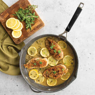 a overhead images of the food cooked in the ceramic coated skillet with chicken, lemon, and pasta.