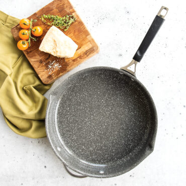 A overhead image of ceramic coated skillet empty with food prepped on the side.