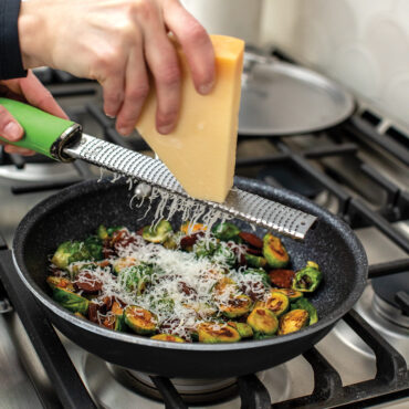 An image grading cheese on top of the brussel sprouts being cooked in the 10" Saute skillet