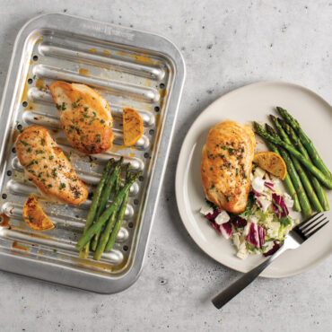 chicken and veggies on Nordic Ware natural aluminum broiler pan with slotted rack, roasted vegetables and meat visible