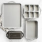 ProCast Everyday Bakeware in group shot in marble background showcasing baking sheet, mini loaf pan, classic loaf pan and 7"x11" baking pan