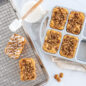 Overhead of baked mini loaves with nut topping and glazing scene on sheet pan.