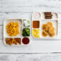 overhead images of kids breakfast and lunch meals on two divided meal trays