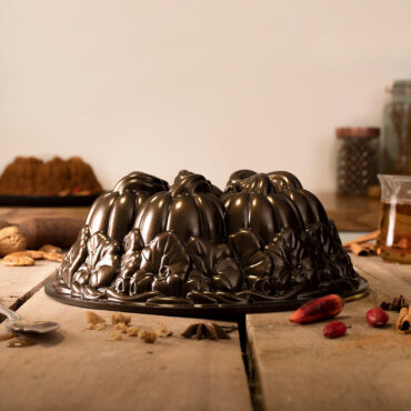 The image captures the Pumpkin Patch Bundt Cake Pan as the focal point, surrounded by a warm and autumnal ambiance.