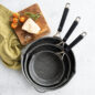 Verde Ceramic Nonstick Skillets nested inside one another next to cutting board with cheese and tomatoes